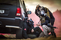 Solider treating a man wearing the CM-6M tactical gas mask